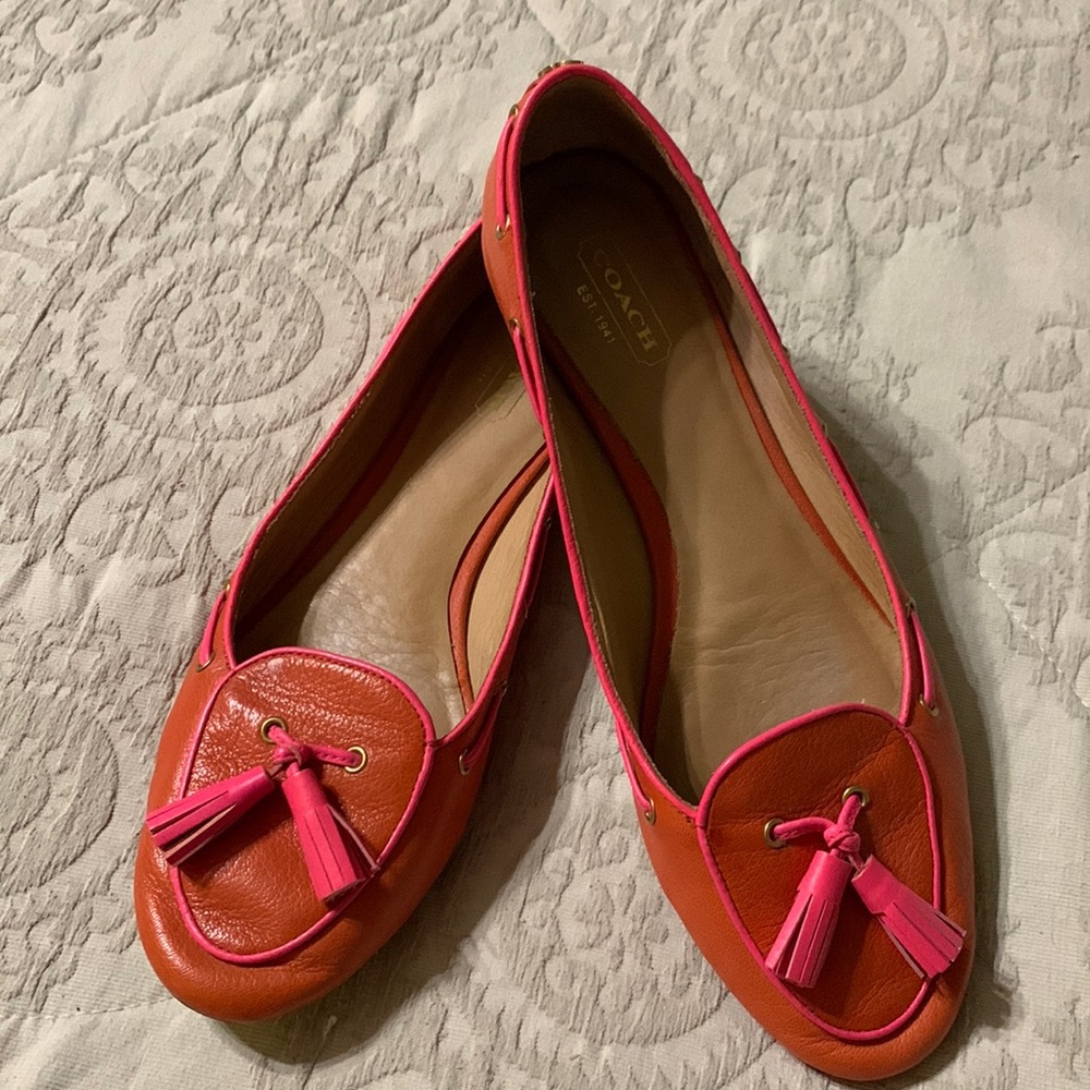 Coach orange leather flats with pink trim and pink tassels in a size 8B.